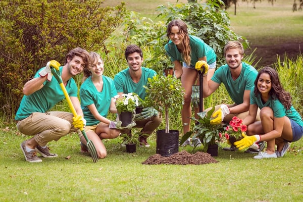 Happy friends gardening for the community on a sunny day