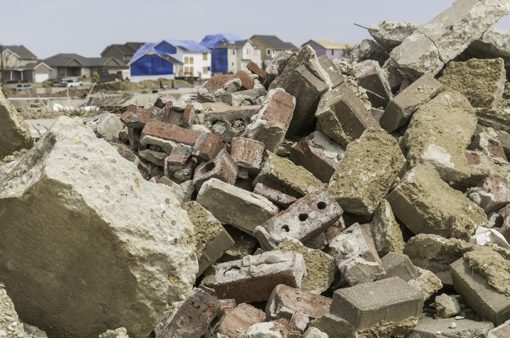 Rubble from destroyed homes remains heaped up in neighborhood where other houses undergo repair during recovery more than 4 months after a tornado in Washington, Illinois, USA.jpeg